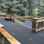 Fiberglass grating platform with wire mesh handrail inserts in a national park, similar to products from Direct Metals®.