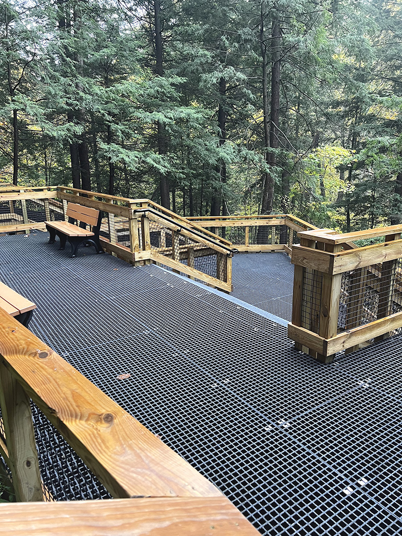 Fiberglass grating platform with wire mesh handrail inserts in a national park, similar to products from Direct Metals®.